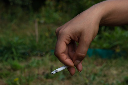 A woman hand is holding a cigarette streetの写真素材