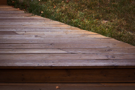 The wooden flooring stage next green lawn.
