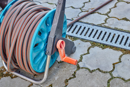 Water hose wound on a reel. Watering work in the garden. Harvest care. water plants.の写真素材