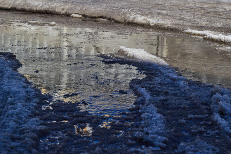 Melted puddle slurry snow and dirt off-road. Thaw. Flooding.の写真素材