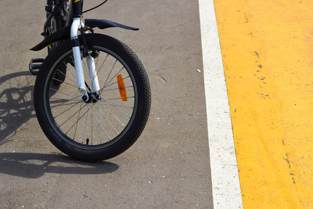Close-up photo of front wheel of bicycle on road. road marking. road traffic. cyclists.の写真素材