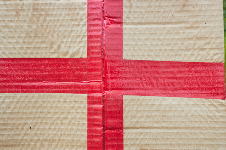 Photo a cardboard box sealed with red tape.の写真素材