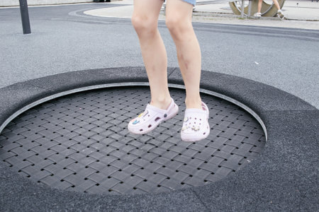 the legs of a child jumping on a trampoline