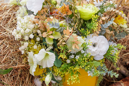 a bouquet of artificial flowers on a straw background.の写真素材