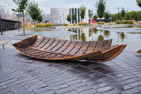 a wooden canoe on the asphalt after the rain.