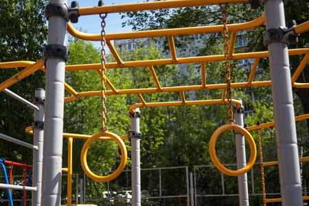 yellow metal playground structure with hanging rings