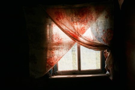 An aged rustic window, curtains and a dark roomの写真素材