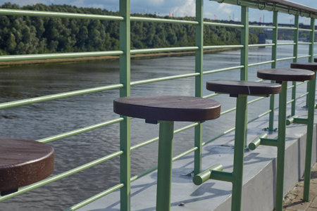 wooden empty stools on the riverbank, embankment.
