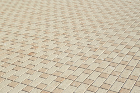 Close-up of a square sand-colored paving stone.