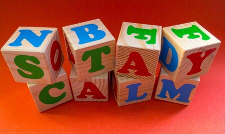 Stay calm message made of wooden kids blocks on orange background. Motivation quote Stay calm for stay-at-home order mode Concepts: isolation, medical, virusの写真素材