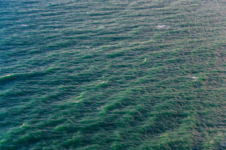 Blue-green waves on the surface of the ocean. Top view of the water. Concepts: background, texture, wavesの写真素材