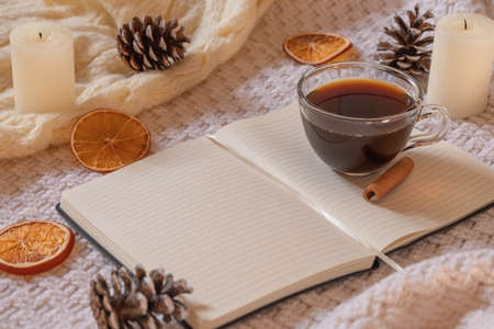Christmas flat lay with notebook, christmas decorations, coffee on knitted blanket. Winter mood, new year resolution, christmas workplace conceptsの写真素材