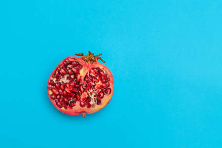 Ripe fresh half of pomegranate on blue background.の写真素材
