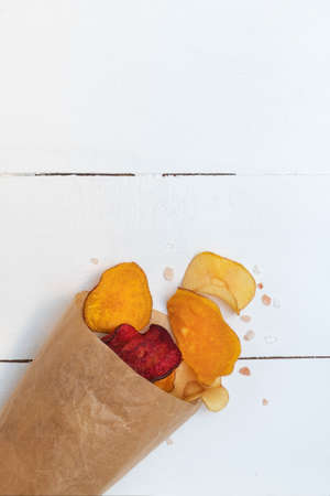 Healthy vegan snack vegetable chips made from carrots, sweet potato, beetroot, parsnip sesoned with sea salt. Image with copy space, top viewの写真素材