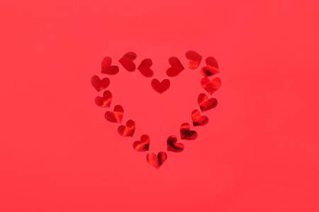 Valentines day background. Shiny red heart on red background. Flat lay, top viewの写真素材