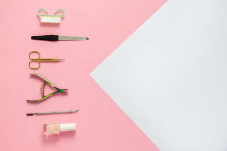 A set of cosmetic tools for manicure and pedicure on a pink and white backgroundの写真素材