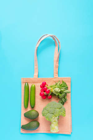 Top view of groceries with eco reusable textile shopping bag on blue backgroundの写真素材