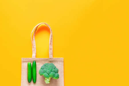 Zero waste and plastic free concept. Top view of reusable textile shopping bag with fresh green...