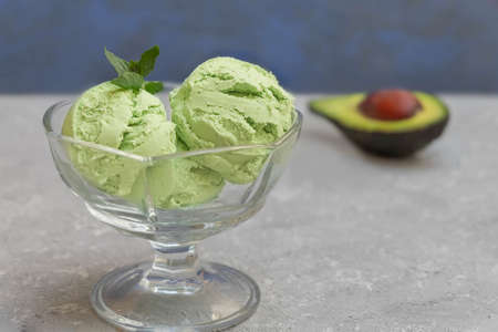 Close-up of homemade avocado ice cream in a glass bowl on dark background