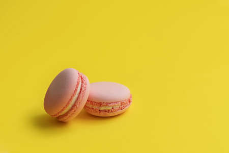 Pink macaroons. Sweet macarons on yellow backgroundの写真素材