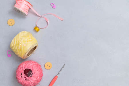 Knitting yarn with crochet hook and DIY accessories on neutral grey background. Flat lay with copy spaceの写真素材
