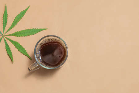Cannabis, hemp, CBD or THC infused black coffee on neutral beige background. Top view with copy spaceの写真素材