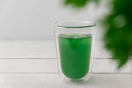 New superfood trend liquid chlorophyll in a cup with water on light background, copy space, selective focusの写真素材