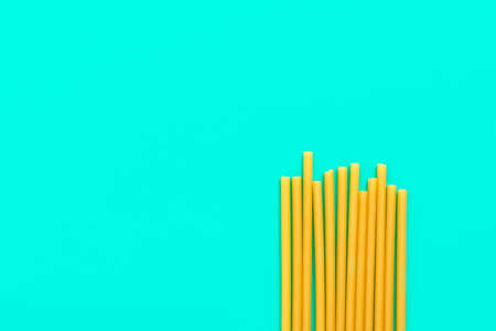 Top view of eco pasta straws on green background with copy space. New trend of biodegradable straws...