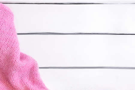 Pink warm knitted plaid on white wooden table with copy space. Flat lay, top viewの写真素材