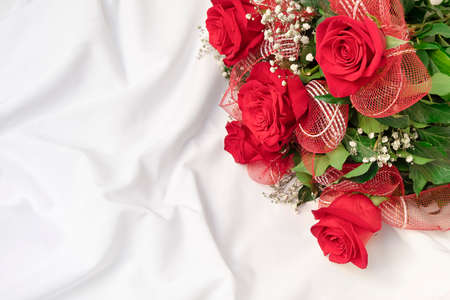 Top view of beautiful bouquet on white bed sheet. Romantic surprise background, copy spaceの写真素材