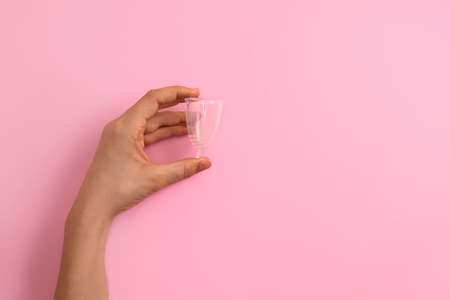Top view of womans hand holding transparent eco silicone menstrual cup, copy spaceの写真素材