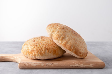 Parlenka, bulgarian flatbread on wooden cutting board on neutral background with copy space