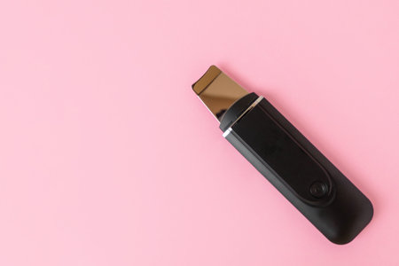 Ultrasonic skin scrubber on pink background with copy spaceの写真素材
