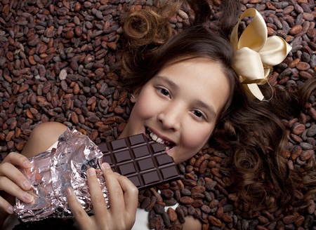 girl with chocolate on cocoa beans backgroundの写真素材
