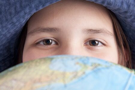 school age girl are looking at camera after the globeの写真素材