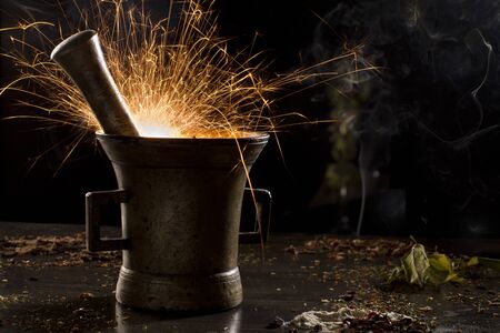 metal mortar with sparkling fire, surrounded with spices