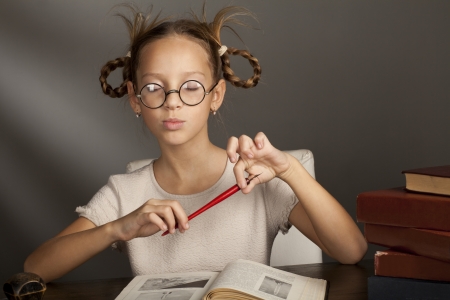 eight years old caucasian girl closed her eyes near the table with booksの写真素材