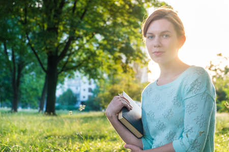 young beautiful girl reading a book in the parkの写真素材