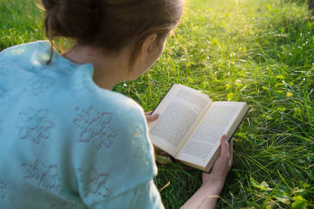 young beautiful girl reading a book in the parkの写真素材