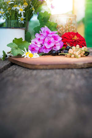 Black and white currant with flowers on wooden boardの写真素材
