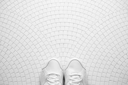 White sneackers on white mosaic pattern. Top view.の写真素材
