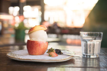 sweet vanilla ice cream in half of apple and little strawberryの写真素材