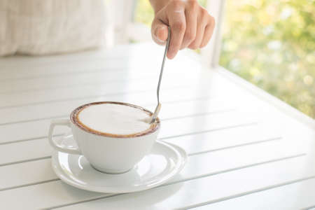 vintage girl drinking cappuccino coffee at cageの写真素材