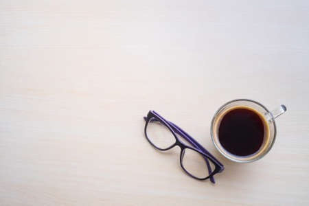 Top view of black coffee and glasses on wooden tableの写真素材