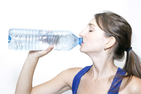 young woman drinking water on a white backgroundの写真素材