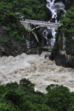 A bridge crossing a stream in Tiger Leaping gorge, Yunnan, Chinaのeditorial素材