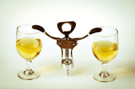 Glass of white wine and corkscrew isolated on a white backgroundの写真素材