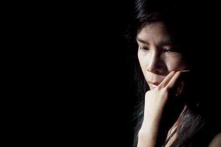 Beautiful Asian girl looking away in deep thoughtの写真素材