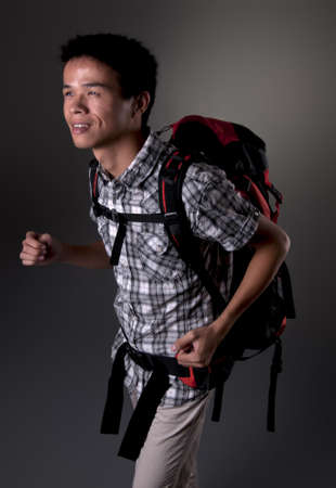 Asian man excited about hiking in the outdoors wearing backpackの写真素材