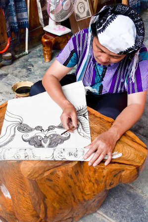 Xijiang, China - July 05:  A traditional woman making a Batik Tapestry in Xijiang, China.  A very traditional technique that is popular among tourists.のeditorial素材